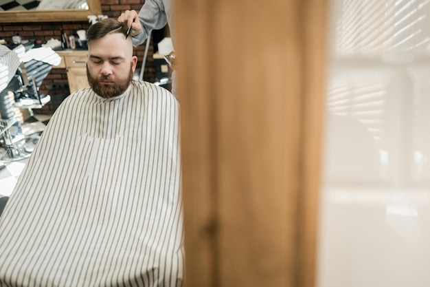 Bärtiger, stylischer Friseursalon-Kunde Er bekommt seinen perfekten trendigen Haarschnitt