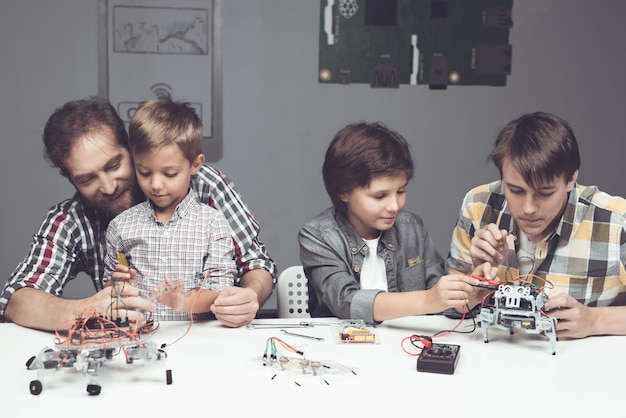 Bärtiger Vater und Söhne, die Roboter zu Hause bauen