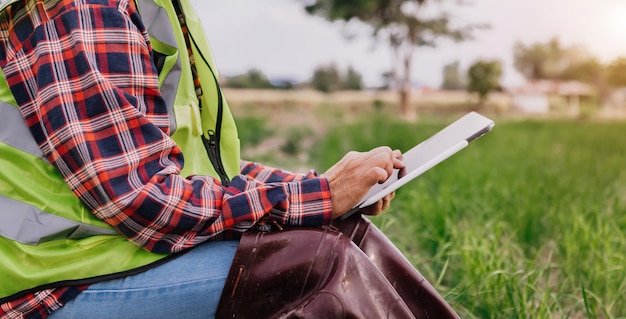 Bäuerin, die digitalen Tablet-Computer in der Feldtechnologieanwendung in der landwirtschaftlichen Anbautätigkeit xA verwendet