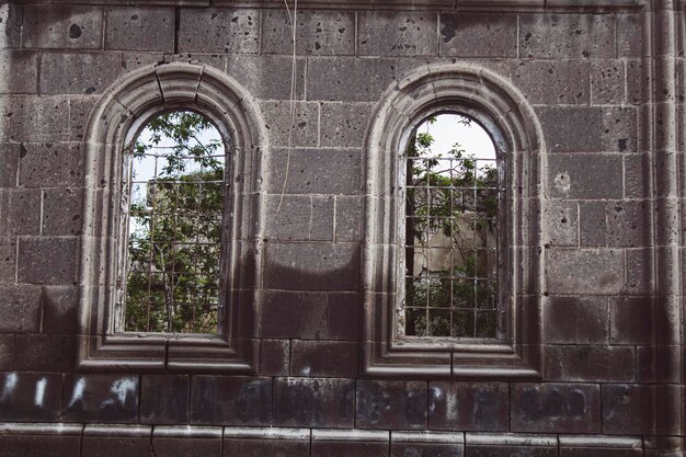 Bäume sind durch die Fenster eines alten zerstörten Hauses sichtbar