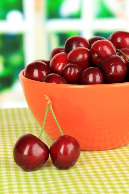 Bagas de cereja em uma tigela na mesa no quarto