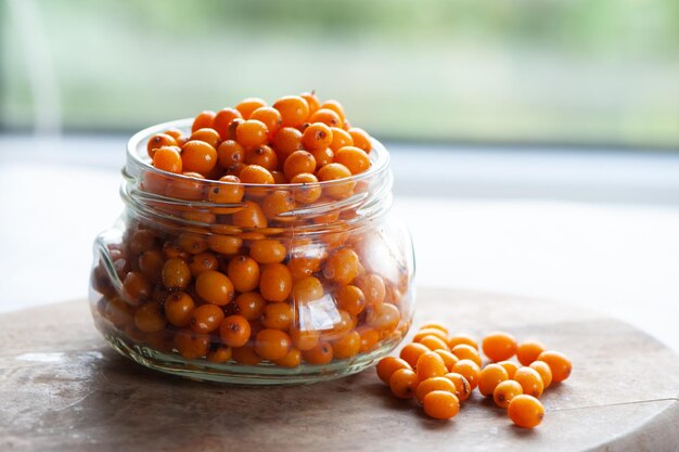 Bagas de espinheiro-mar em uma jarra macro de bagas saudáveis de laranja