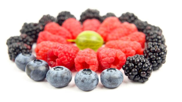 Bagas diferentes em um círculo sobre um fundo branco. Alimentos úteis com frutas vermelhas e vitaminas