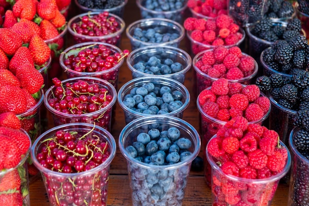 Bagas frescas e suculentas no mercado do agricultor conjuntos de frutas diferentes coloridas no café de rua