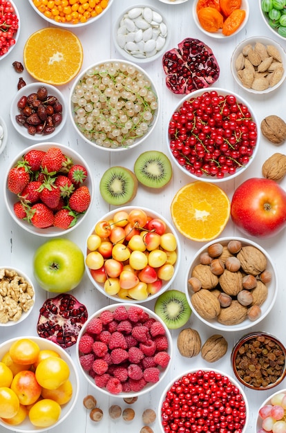 Bagas frescas, frutas, nozes em uma madeira branca