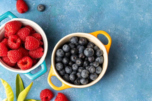 Bagas frescas Mirtilo e framboesa em tigelas de cerâmica Vista superior de alimentos de frutas coloridas