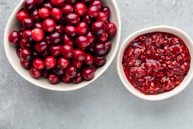 Bagas vermelhas em um fundo escuro. cranberries em uma tigela.