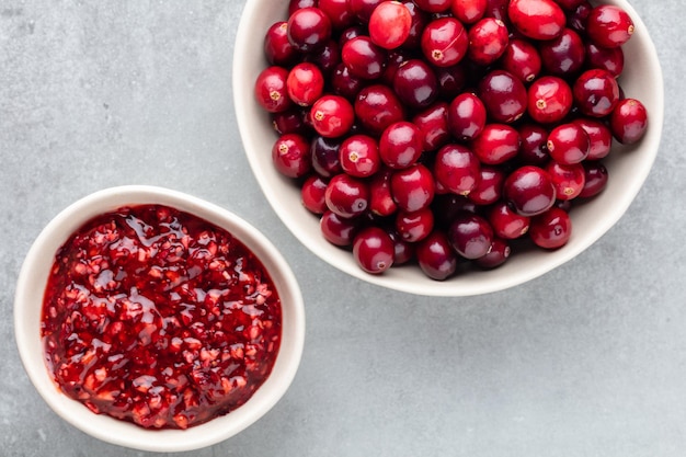 Bagas vermelhas em um fundo escuro. cranberries em uma tigela.