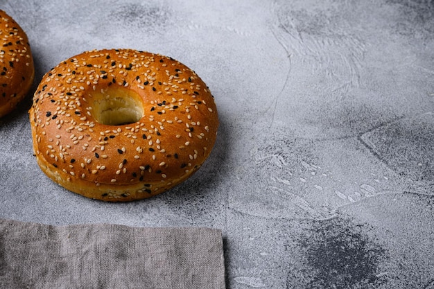 Bagel de gergelim fresco definido no fundo da mesa de pedra cinza com espaço de cópia para texto