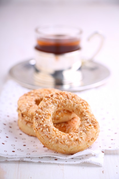 Bagel mit Samen des indischen Sesams und einer Tasse Tee auf einem weißen Hintergrund