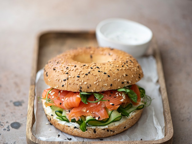 Bagel con salmón salado, pepino y queso crema