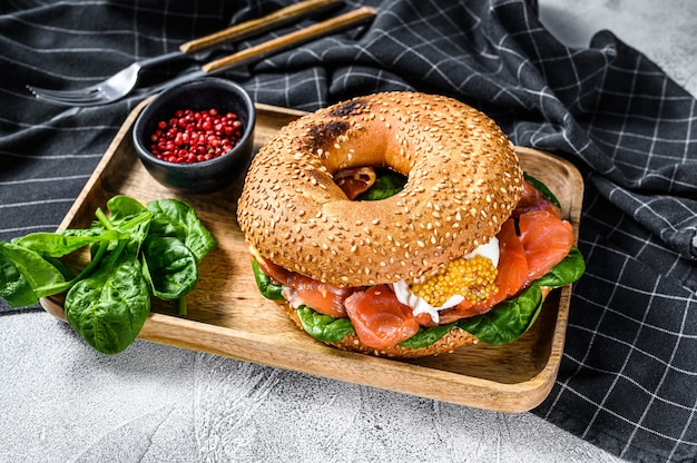 Bagel saludable recién horneado relleno de salmón ahumado, espinacas y huevo