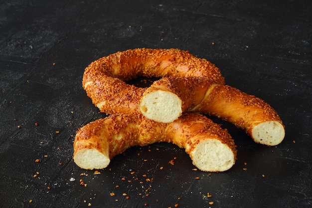 Bagel simit turco espolvoreado con semillas de sésamo sobre un fondo negro