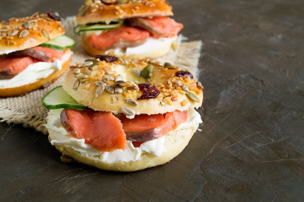 Bagels com cream cheese e salmão defumado em um fundo preto