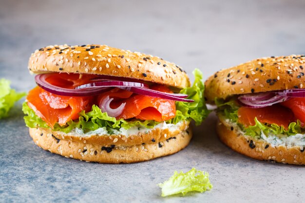 Bagels com cream cheese, peixe defumado, cebola roxa e alface.