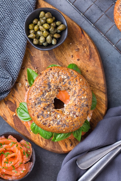 Bagels com salmão defumado, cream cheese e alcaparras em uma mesa. Comida, almoço, brunch, refeição no prato, conceito de placas