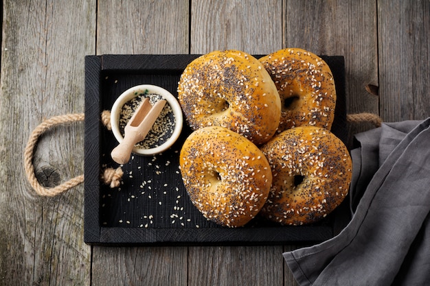 Bagels em caixa rústica de madeira com guardanapo de têxteis em fundo de madeira velho