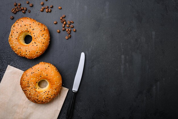 Bagels frescos com gergelim em fundo de mesa de pedra escura preta vista superior plana com espaço de cópia para texto