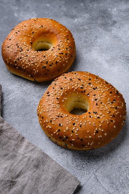 Bagels frescos com gergelim no fundo da mesa de pedra cinza