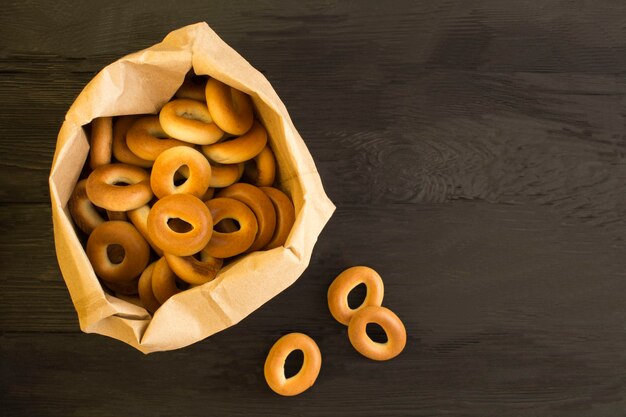 Bagels en el paquete de papel sobre la mesa de madera negra