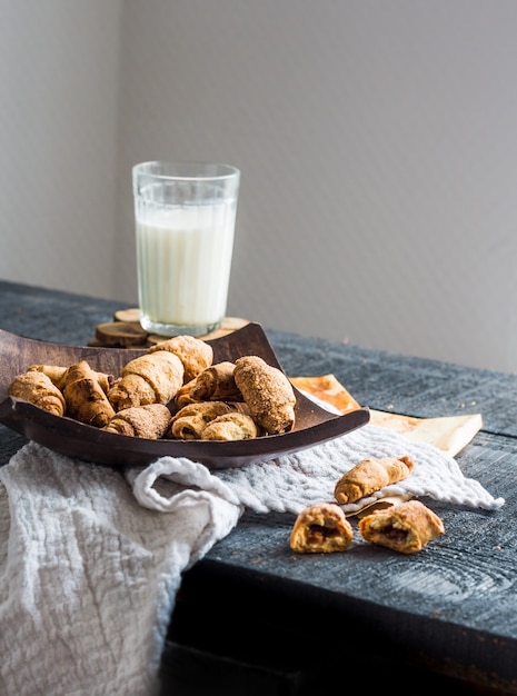 Bagels de queso, galletas de bollos, leche, postre en una madera