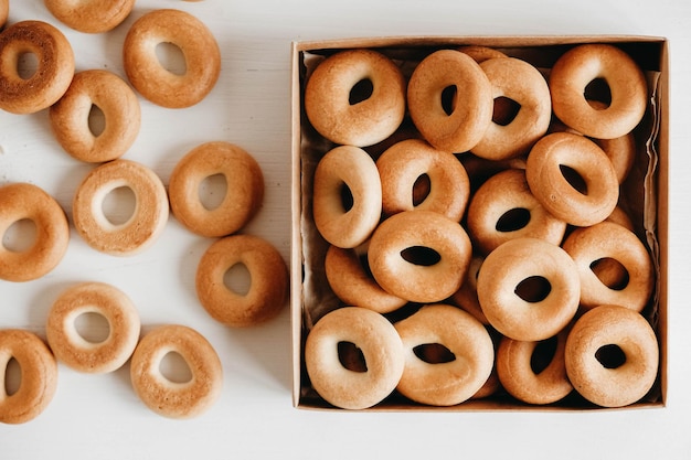 Bagels secos o redondos en una caja de papel sobre un fondo blanco de madera