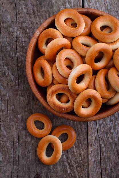 Bagels en un tazón de madera sobre un fondo oscuro