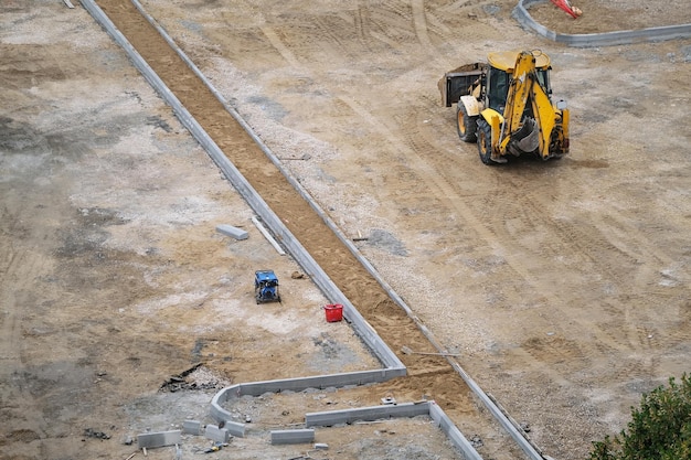 Bagger auf Sandbaustelle eines Parkplatzes, Draufsicht