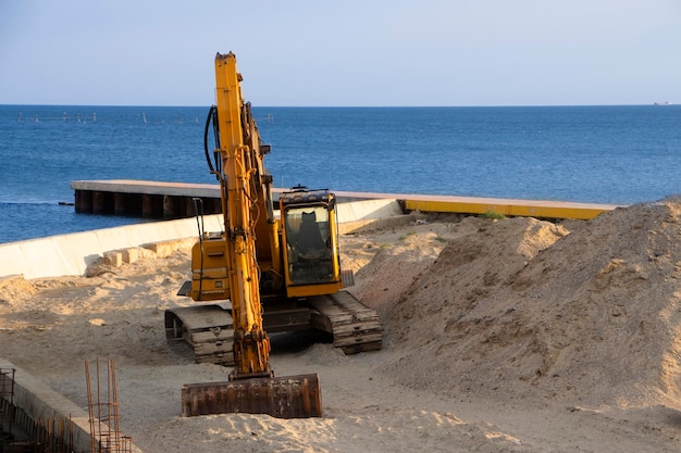 Bagger auf See begradigt den Sand für den Strand