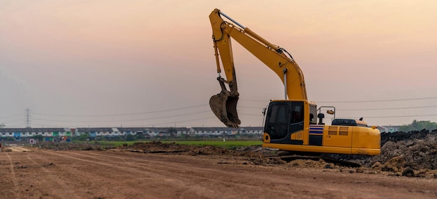 Bagger, der auf der Baustelle bei Sonnenuntergang arbeitet