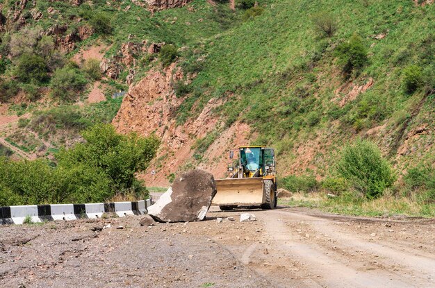 Bagger entfernt nach einem Erdrutsch Steine von einer Bergstraße