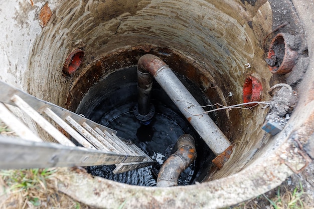 Bagger heben die Gräben auf einer Baustelle aus Graben zum Verlegen von externen Abwasserleitungen Abwasserentwässerungssystem für ein mehrstöckiges Gebäude Ausheben des Grubenfundaments