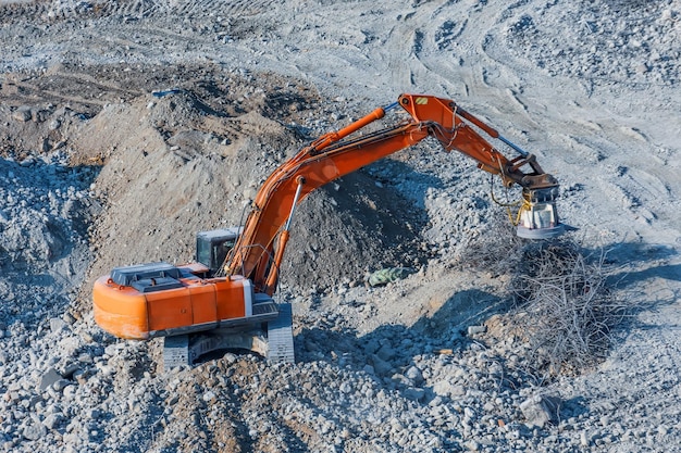 Bagger mit einem Magneten am Ausleger zum Laden von Metallabfällen