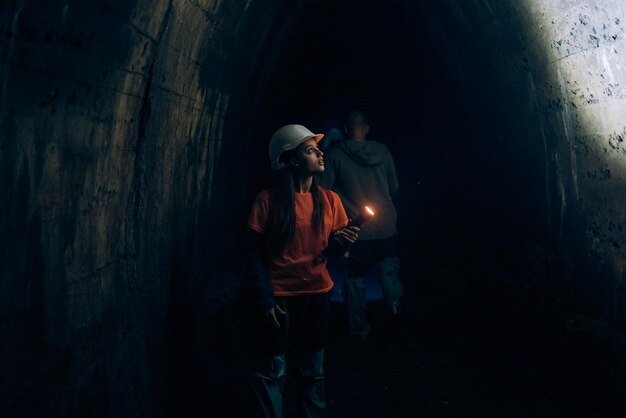 Baggerin mit Taschenlampe erkundet den Tunnel