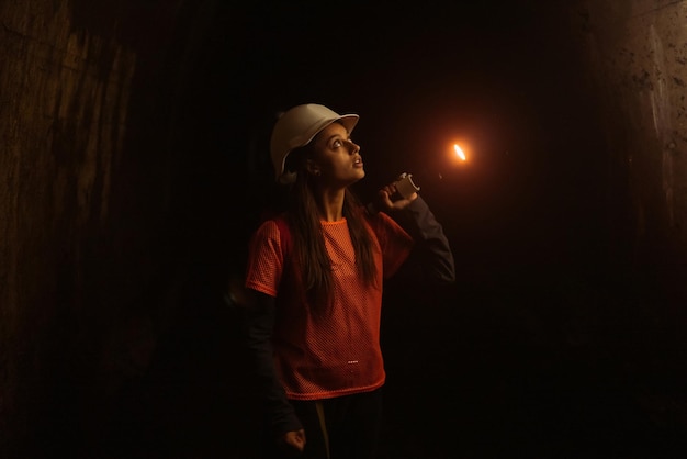 Baggerin mit Taschenlampe erkundet den Tunnel