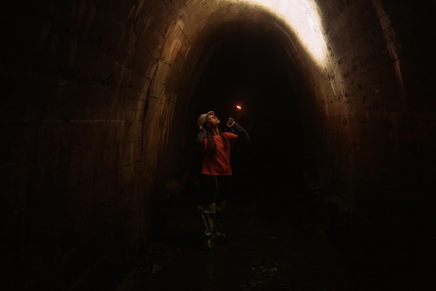 Baggerin mit Taschenlampe erkundet den Tunnel