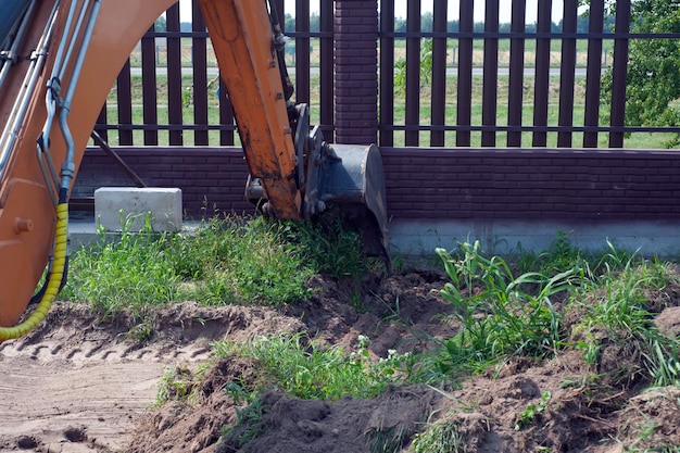 Baggerschaufel Nahaufnahme auf dem Hintergrund einer Baustelle Schwere Erdbewegungsmaschinen Bodenentwicklung