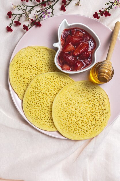 Baghrir marroquí tradicional casero con miel, fresas y menta. Panqueques marroquíes desde arriba