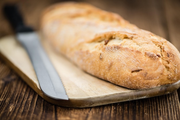 Baguete assada fresca em foco seletivo de fundo de madeira