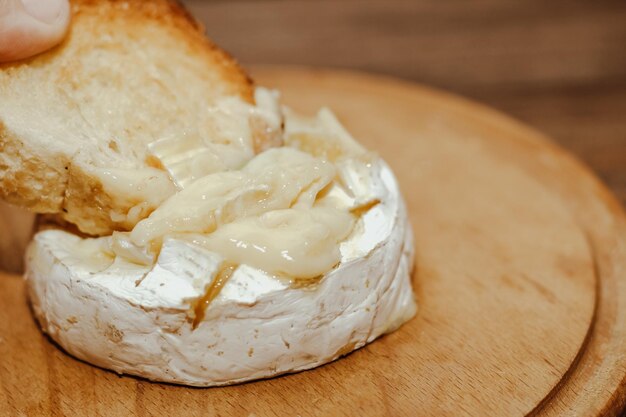 Baguete branca com azeite e queijo Camembert assado em cima da mesa