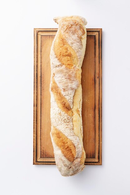 Foto baguete caseiro em prancha de madeira close-up azeitona pão italiano isolado em branco