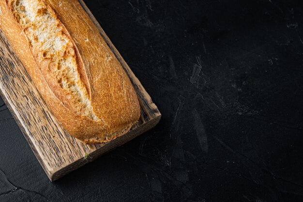 Baguetes francesas crocantes, em fundo preto com espaço de cópia para o texto