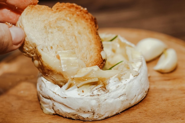 Baguette blanca con aceite de oliva y queso Camembert al horno sobre la mesa