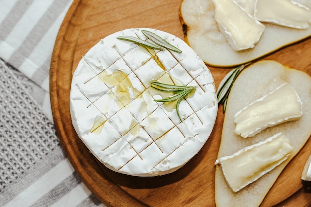 Baguette blanca cortada en trozos con aceite de oliva y queso Camembert sobre la mesa