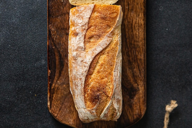 Baguette-Brot-Nahrungsmittelsnack auf dem Tischkopierraum-Lebensmittelhintergrund rustikale Draufsicht