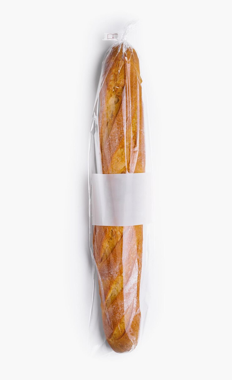 Baguette fresca en envoltura de plástico aislada en blanco