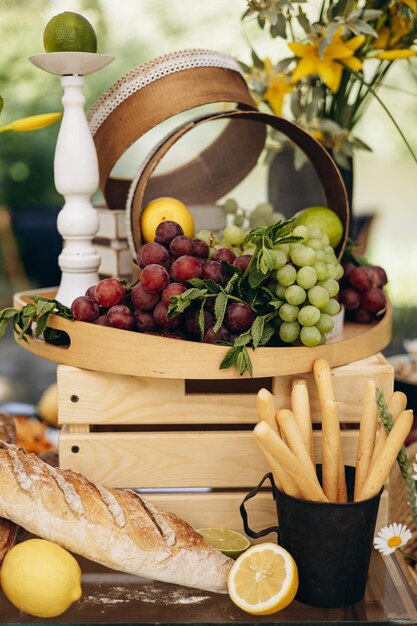 Foto baguette y frutas y uvas en la mesa de bocadillos de boda