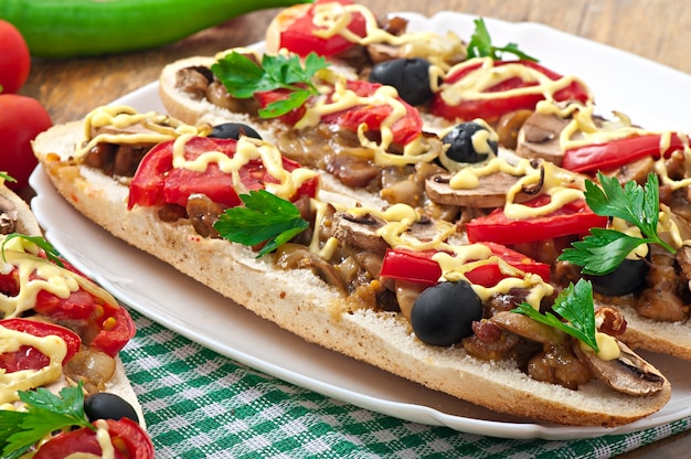 Baguette gefüllt mit Kalbfleisch und Champignons mit Tomaten und Käse