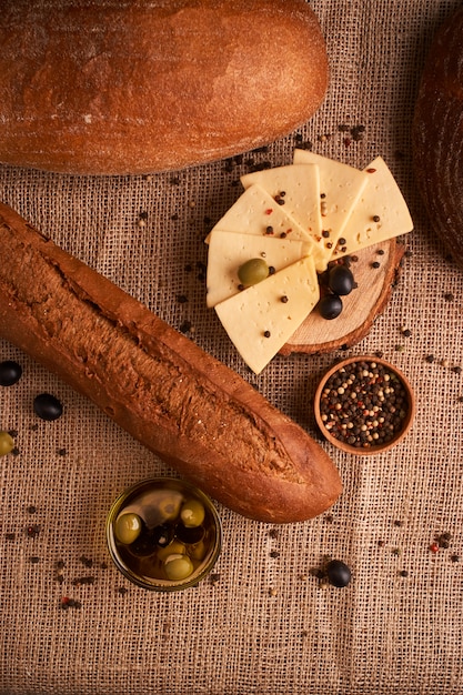 Baguette italiana fresca en la tabla de madera con aceite.