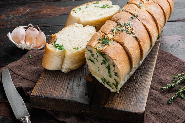 Baguette con mantequilla de hierbas de perejil sobre fondo de mesa de madera oscura vieja